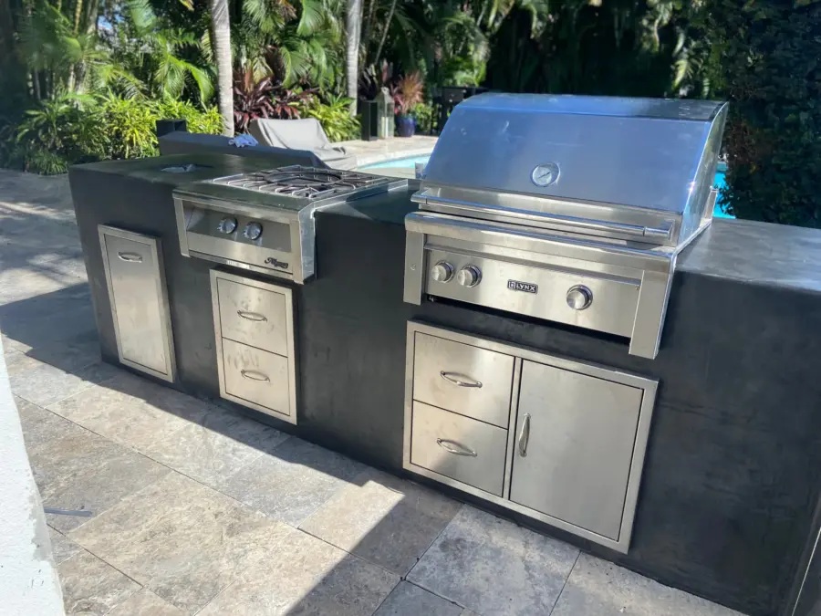 Outdoor kitchen island with smooth charcoal finish, Lynx grill, side burner and stainless drawers
