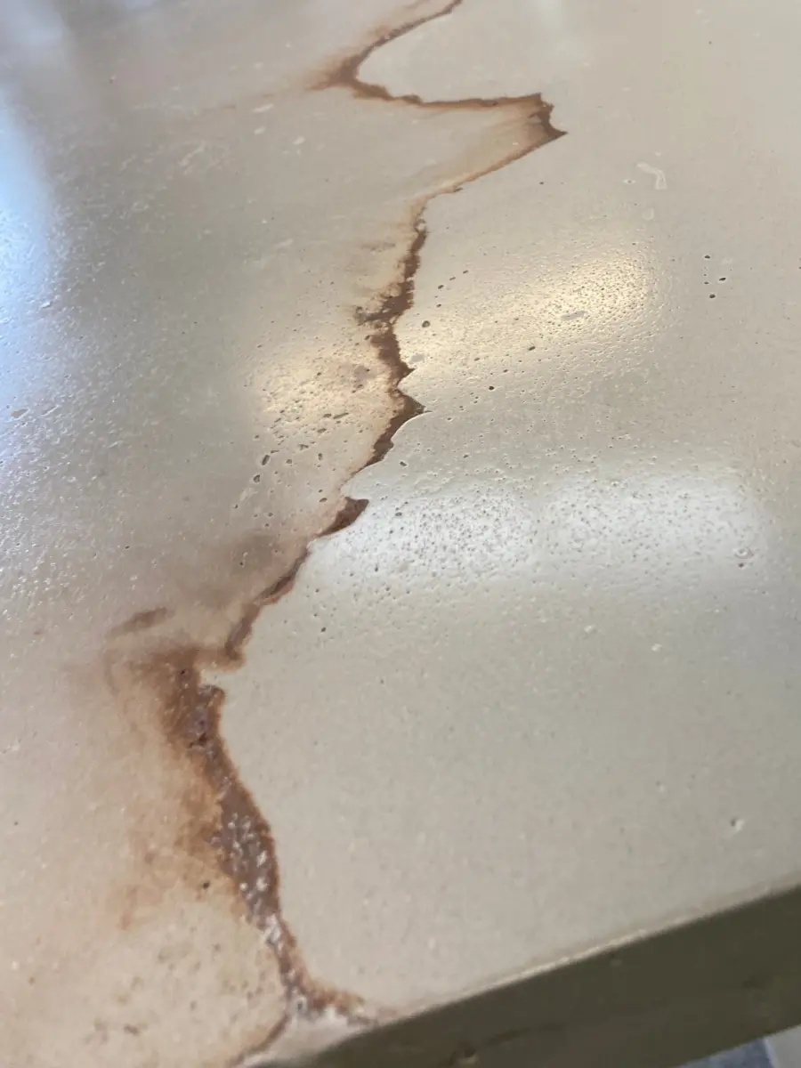 Cream concrete countertop with rust-colored veining, polished surface, close detail