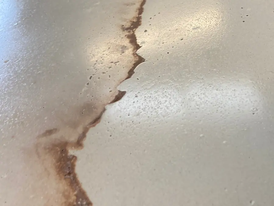 Cream concrete countertop with rust-colored veining, polished surface, close detail